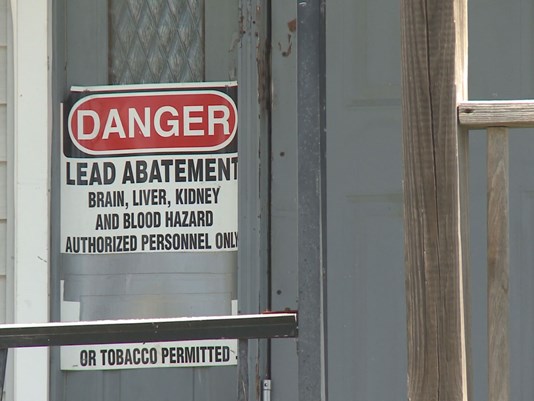 Picture of danger sign on door and stairs with chipping and peeling paint